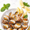 Chilled spotted Babylon snails on ice with lemon